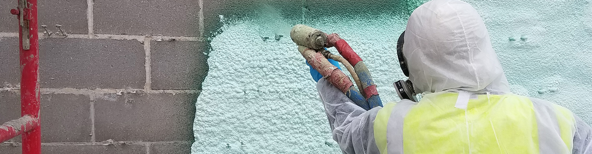 spray foam being applied over wall